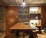 Dining Room, Bench, and Concrete Floor Custom-designed furniture outfits the interior of a bunker-turned-vacation retreat in the Netherlands.  Photos from Dutch Military Bunker Becomes Tiny Vacation Home