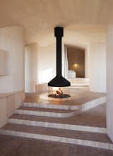 This house is also set within rustic settings - a Norwegian forest - but its firepalce has a more refined palette: marble hexgon tiles surround the flames while the remaining floor riles are birch.