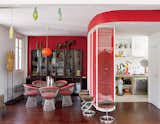 A far cry from minimalism, the renovated 900-square-foot Paris flat belonging to Nicolas Roche, a scion of the French furniture company Roche Bobois, is decked out with vivid hues and vintage furniture. A 1960s orange lamp by Luxus is suspended over the Warren Platner dining table and chairs. The 1950s rosewood glass cabinet is from Soriano. Pod Lens pendants by Ross Lovegrove for Luceplan hang from the ceiling.
