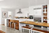 A new addition, adjacent an old bungalow in Austin Texas, is covered in dark cypress panels but features a luminous white interior accented by the marble's veins and the rich grain of reclaimed wood.