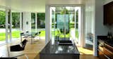 Custom cabinets and a faucet from Kohler’s Purist collection are complemented by Luciano Bertoncini’s Min table and Spoleto chairs by Knoll. A Paulistano armchair, designed by Paulo Mendes da Rocha, sits nearby.