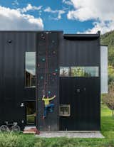 Dotted with colorful footholds, a climbing wall covers one side of the home, allowing roof access.