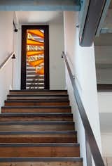 The staircase leads from the living room to an exterior balcony, where a second spiral staircase leading to the rooftop balcony was painted bright tangerine orange. The roof deck spans the entire footprint of the home.  Photo 9 of 10 in A Dull Stucco Home Becomes a Modern California Oasis
