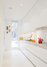 The galley kitchen, in classic white, is the one splurge within the interior: it was custom made by Bulthaup from their B1 series. A narrow window, with a frosted bottom panel, balances views and privacy.
