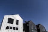 Bestor Architecture, Blackbirds, Echo Park, Los Angeles
Blackbirds is a development of eighteen houses embedded in the hills of Echo Park; a progressive solution for high-quality dense housing in a city with little available land. The homes range from 1,200 to 1,900 square feet and are built around a living street; a central courtyard that comprises both landscape and parking areas, and serves as a stage for larger community functions. The placement of the houses in the hills mimics the older wooden houses of the area and deploys a strategy of “stealth density,” combining several houses into a single house-shaped volume. For instance, two free-standing houses are connected by flashing and the roofline creates the illusion of one house mass. Three houses, whose separation is masked, creates the illusion of two houses. This conceals the density of units by maintaining the neighborhood shape and landscape across the site. The community is a blend of private, semi-private, and public space, and promotes a sense of neighborhood by encouraging interaction and exchange.