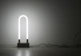 Sarah Pease (Rhode Island School of Design), T12 Light, 2011. The T12 light is a shining example of simple, premade materials deployed in an elegant fashion. The black walnut and aluminum base supports an industrial, U-shaped fluorescent lightbulb, set off by a braided fabric cord.