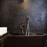 When in doubt, go with black: In a 495-square-foot attic in the Söder neighborhood of Stockholm, interior designer Jimmy Schonning has carved out a sweet and stylish home. His diminutive studio is loaded with black tiles and fittings for a dramatic look.