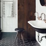 In the master bath of this Montreal triplex, a dowdy tub was replaced with a standing shower. The wall and floor tiles are by Ceragres, and the sink, tub, and towel rack are by Aqua Mobilier de Bain.