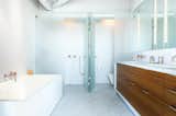 “The structural elements were left rough and exposed while the baths were designed to be clean and sleek,” Severns says. The bathroom is by Henrybuilt.