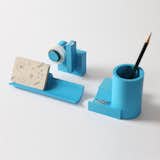 The Merge Concrete Desk Set is a collection of desktop items including a pen holder, cardholder tray, and tape dispenser. The Merge series is united by the enduring principles of geometry and the industrial appeal of concrete.