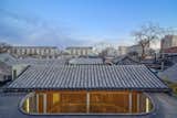 The roofs were also renovated but maintain their traditional pitched roofs. The new glass enclosure can be seen below.  Photo 4 of 7 in A Historic Beijing Structure Gets a Modern Makeover