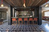 This modern bar in Oaxaca is named Expendio Tradición, meaning “dispensing tradition,” a concept designer Ezequiel Farca utilized to create a space that’s seeped in the Chagoya family’s 140-year-old tradition, producing mezcal. Materials such as recycled mezcal barrels, traditional black clay tiles, and handmade cement floor tiles, which generated local work and economic sustainability, are featured throughout the space.