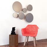 The Black Wall Mirrors are a sculptural wall hanging. Each mirror in the series is structured in a semisphere, adding depth to the mirror. The glass has a slight black tint finish, which gives off a clean reflection with a subtle darkened tone.
