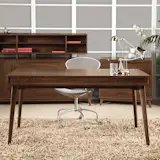 The Catalina Desk is an elegant furnishing that is defined by its simple silhouette. Resting on four splayed legs, the Catalina Desk is comprised of a rectangular tabletop that includes a drop down keyboard tray. The desk can be used as a conventional desk in an office, or as a distinctive accent in an entryway or hallway. Crafted from American black walnut wood, the Catalina Desk features a rich, warm wood grain.