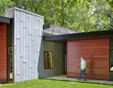 A tall gray wall, made of acid-washed zinc metal, marks the entryway and visually grounds the roof planes. It also separates the living and bedroom volumes.