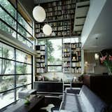 When architect Andrew Lister designed this wedge-shaped, Japanese-style house outside of Auckland for actor Yuri Kinugawa and film producter Owen Hughes, he wanted to make the interior feel larger than it was. The vertiginous two-story bookcase that takes up the entire northern wall of the living room draws the eye upwards, adding spacial impact without taking up any floor space.