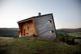 Sebastian Heise’s wooden structure, seemingly atilt, overlooks a green valley in Oberwiesenthal, Germany. The two horizontal windows on the side and the front porch give the home its own unique sense of balance.