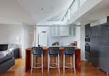 Inside, bar stools by Anibou, appliances by Miele, and gray cabinets from IKEA furnish a simple kitchen.  Photo 6 of 10 in An Off-the-Grid Prefab that Combines Open Plan Living With Rugged Durability