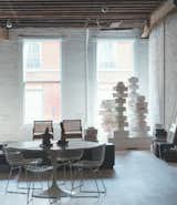 At his Tribeca loft, artist Will Cotton displays his large 2012 plaster cake sculpture, Against Nature, in the street-facing window. Two Chandigarh chairs by Le Corbusier, a Tulip table by Eero Saarinen, and a series of wire chairs by Harry Bertoia furnish the space.