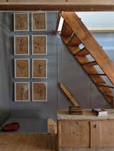 Wood stairs lead from the ground floor to the stübli; another set leads up to the mezzanine bedroom. The children gathered and dried the flowers hanging on the wall.  Photo 9 of 12 in A Sliced-Up House Comes Together Again