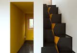 A corridor-like entrance invites residents into the home. The architects chose to use goose-step stairs because of their safety and efficiency in compact spaces. “This staircase is also the easiest in terms of construction,” Kolchin says. “It is nearly impossible to make any mistake while building it.”