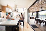 Kitchen, Wood Cabinet, Light Hardwood Floor, and Ceiling Lighting The residents, a family of three, spread out over the house's four bedrooms and two living areas.  Photo 8 of 8 in A Modular Beach Home in Australia Allows One Family to Keep an Eye on the Surf from Outdoor Dining Areas We Love October 19, 2015
