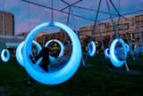 An installation brought 20 circular, glowing swings to a grassy area near the Boston Convention Center. LED lights embedded in the polypropylene swings change color depending on its motion.