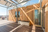 Clad in warm larch wood, the dwelling features a canopy that serves as a trellis for plants and provides shade for the house to reduce cooling loads. The six foot long solar clothes dryer, laid on its side, camouflages as a comfortable bench.