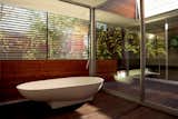 The master suite dominates the second floor of the house. The large master bath is separated into two areas—a toilet and sink zone, and a wet area where the tub and showers can drain into the plank floor. Sliding glass doors open the bathing area onto the deck, which connects on the other side to the master bedroom.