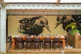 Dining Room, Table, and Chair Local artist Melissa Terrezza painted this mural inside the property. “We have three murals in the containers that she worked on,” said Kristie Quinn, the restaurant owner’s business partner. The building’s lighting is all LEDs from Rexel.  Photo 1 of 7 in Less is More by Dwell on Design from A Restaurant Constructed from 19 Salvaged Shipping Containers