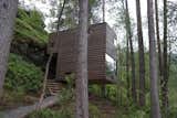 The two new cabins, also by Jensen & Skodvin Architects, are built on a steep hillside. They are held aloft by narrow steel rods and clad in a lumber stained to blend into the natural surroundings.