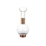 The striking glass-and-copper Tank Jug Glass Pitcher, designed by Tom Dixon, resembles a piece from a chemistry set.