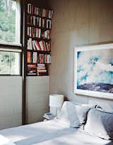 Bedroom, Bed, Table Lighting, Shelves, and Bookcase In the master bedroom, above the Legnoletto by Alias bed, is a photograph by John Huggins. The lamp is from Ikea. “Nothing is painted—all that stripping is about getting to the natural surfaces of the wood, and the concrete block,” Norelius says.  Photo 2 of 2 in Bedroom by Rohit Ajmera from L.A. Renovation Respects Midcentury Bones (While Adding Some Flair)