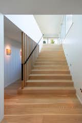 Custom bleached-white oak flooring covers the floors, including on the staircase to the property’s second floor. Juno five-inch LED recessed wall lighting illuminates the steps at night.