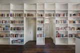 A wall of built-in shelving runs the length of the space, providing ample room for the residents' book collection.