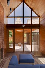 A Douglas fir ceiling in the screened porch and red bricks are accented by blue Arizona modular outdoor seating by Barlow Tyrie.