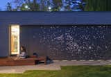 Architect Janna Levitt laser cut an astral pattern into the garage door of this renovated Toronto home, installing LED lights behind the fiber-cement surface to complete her depiction of the constellations Sagittarius and Scorpio.