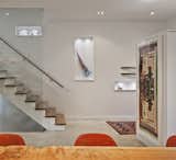 A custom glass structure supplied by Reale Born Inc. borders the stairs, which are made of solid white oak.