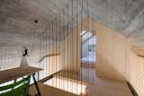 Steel rods surround the staircase. A MayDay lamp by Konstanting Grcic for FLOS is affixed to the rope wall.