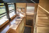 The all-wood interior features standard home appliances, such as a sink, induction cook top, and refrigerator.
