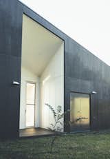 Exterior, Concrete Siding Material, Glass Siding Material, Flat RoofLine, and House Building Type The house uses solar panels and water tanks to function off the grid. Its waste water is recycled and used for irrigation.  Search “solid dark mt masking tape set of 10” from Modern House Captures Panoramic Views in Australia