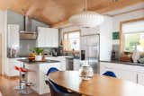 The kitchen features Ikea Sektion cabinets and Whirlpool appliances. The dining area contains a table from CB2, a George Nelson pendant, and Eames molded fiberglass chairs that were picked up at the Alameda Flea Market.