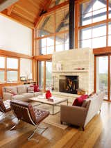 The design pairs durable steel construction on the outside with warmer timber frames on the interior. At the center of the expansive glass wall stands a two-sided fireplace that can heat the deck outside and living room within. Seen here are a Restoration Hardware Brickmaker’s coffee table and sofas from Lee Industries.