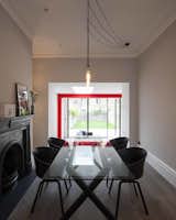 Black HAY dining chairs and Hooked pendants by Buster and Punch contrast with the dining room’s rustic floorboards, by Eco Hardwood, and the fine detailing of the fireplace.  Photo 5 of 8 in A London Town House Renovation Beaming with Personality