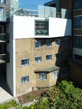 A stepped back view shows the confined site, bracketed by multi-unit residential buildings. The lone window is angled to grab maximum light while protecting privacy.