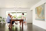 In the dining room, the family gathers beneath a cluster of IKEA Ranarp pendants.