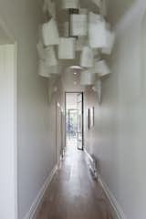 An Ingo Maurer Zettel’z 5 chandelier hangs in the entry hallway; sunlight from the home's expansive backyard is already visible on the white smoked oak floors.