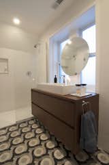 Shively describes himself as "big on graphics" and designed these tiles, produced by Original Mission Tile in San Luis, Mexico, to add his own flair to the master bathroom. A simple floating vanity and minimalist shower let the custom tilework take center stage.