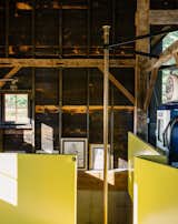 Shed & Studio and Den Room Type The contractor sourced the brass pole from a fire station in Boston. The surrounding wall is painted in semi-gloss paint in Citrus by Sherwin Williams, a sunny hue the team playfully referred to as Dwell-ow.  Photo 9 of 13 in A Passive House and “Sauna Tower” Join a 19th-Century Barn in the Hudson Valley