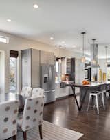 “Because the property is so narrow, we had to be strategic in laying out the plan,” Mitchell says. “Our goal was to create an open plan that spanned from exterior wall to exterior wall in order to make the home feel as large as possible.” Solid oak flooring fills the space and pendants from Kenroy Home illuminate the kitchen.